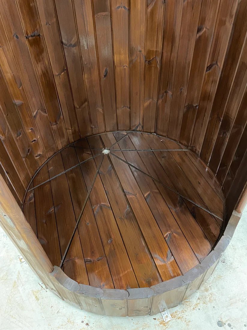 Barrel shower with metal grating and curved roof.