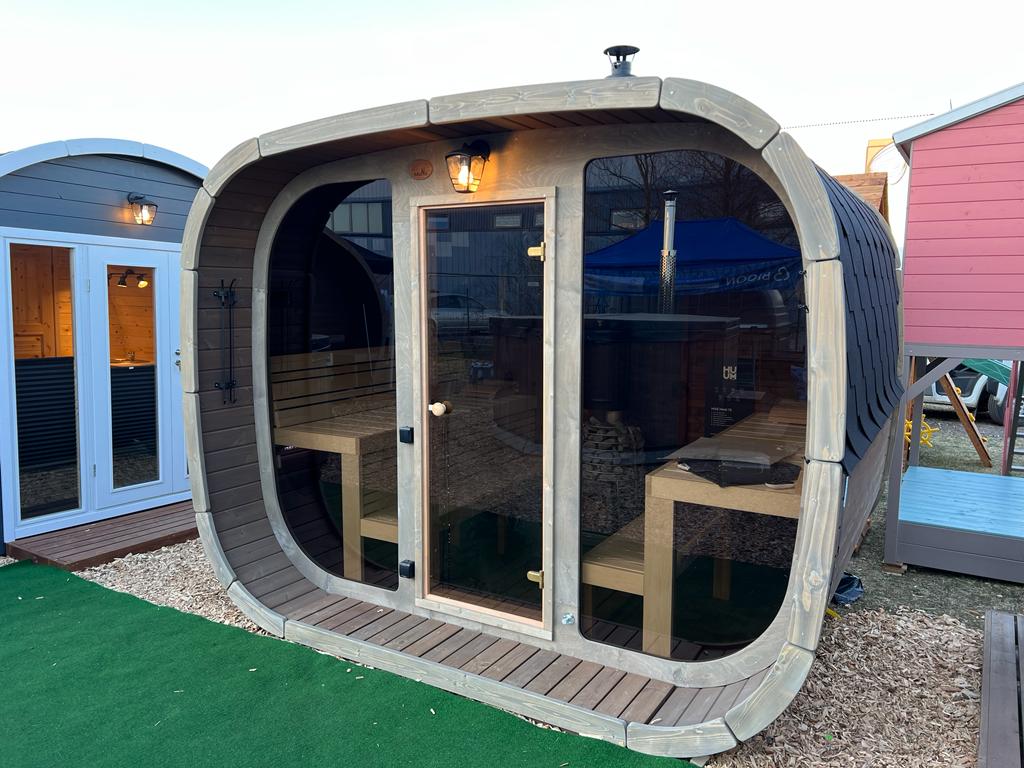 Sauna exterior Cubus con puerta de cristal y estructura de madera.