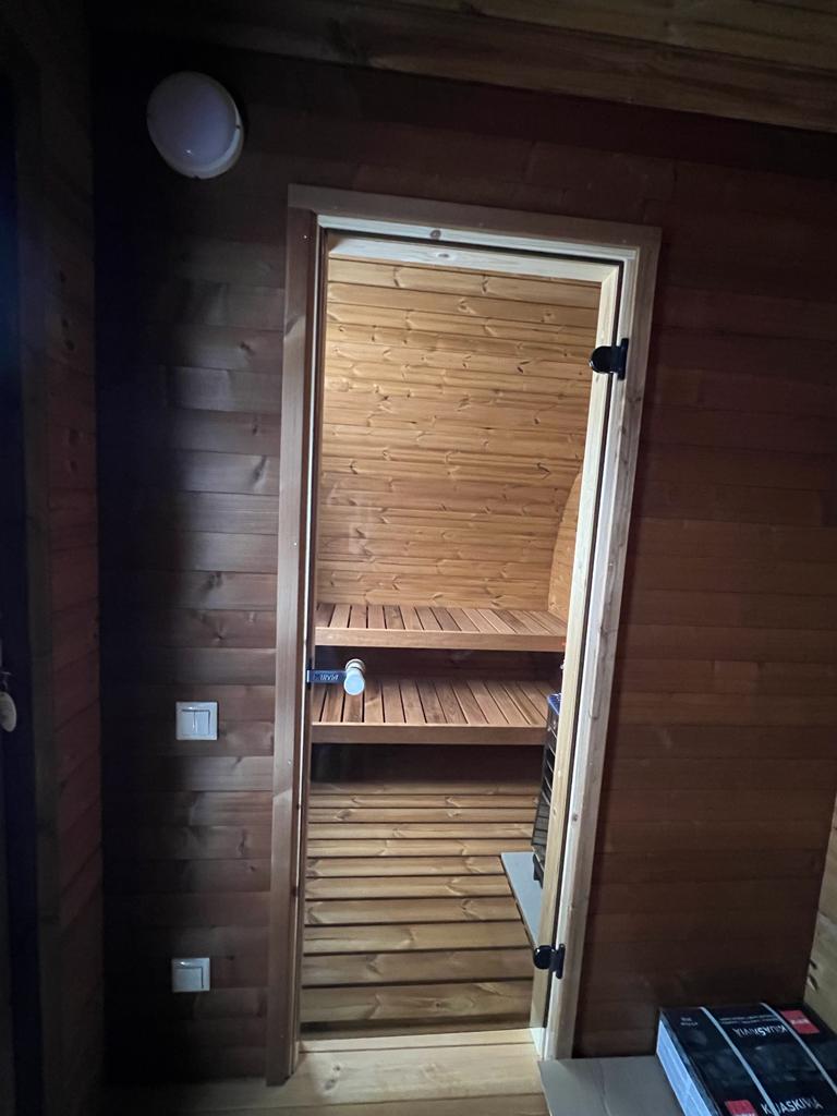Hobbit 195 outdoor sauna with open glass door.