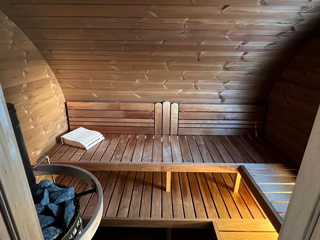 Sauna extérieur Hobbit 500 avec banc et seau en pierre.