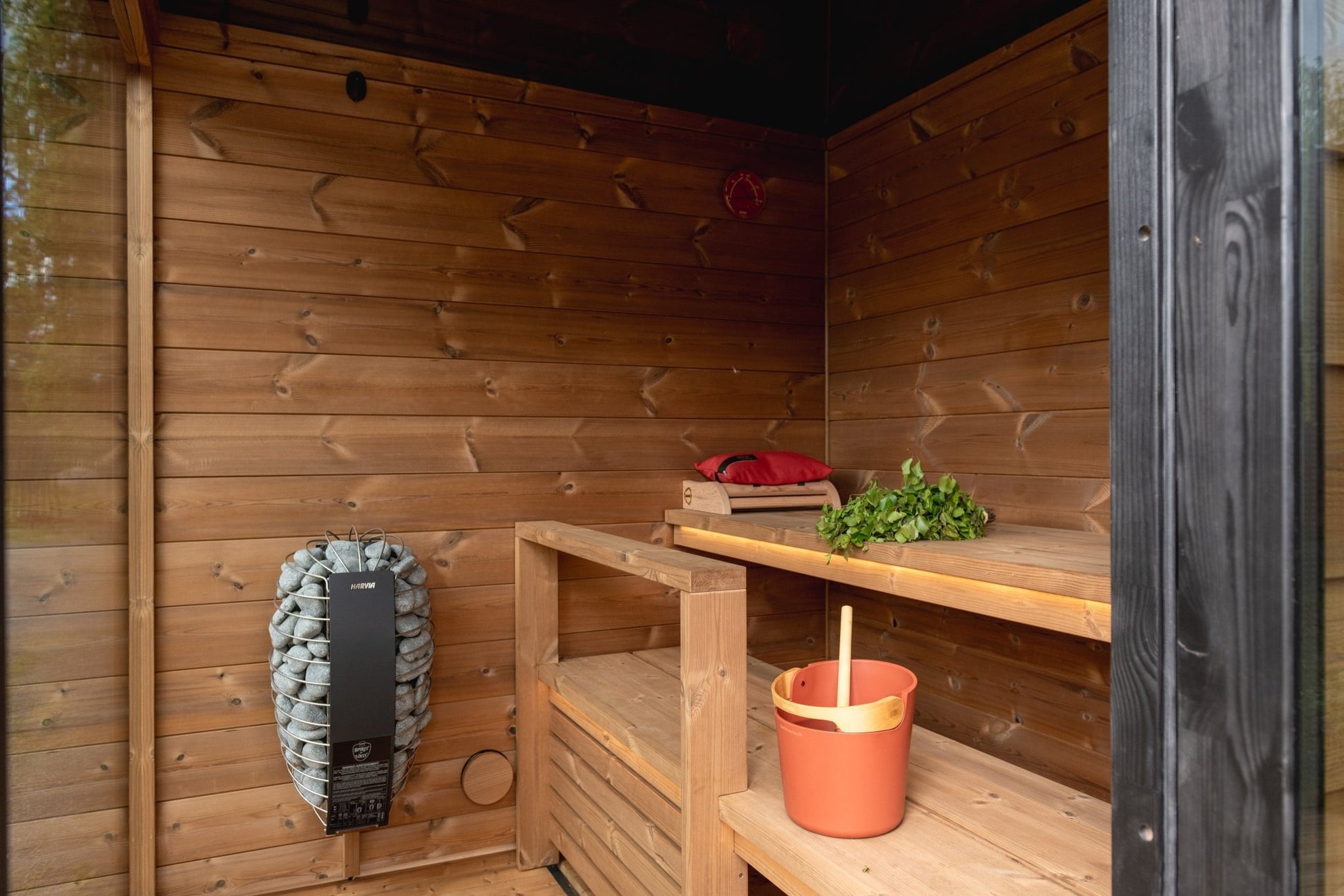Nordic Dawn outdoor sauna with bucket and herbs inside.