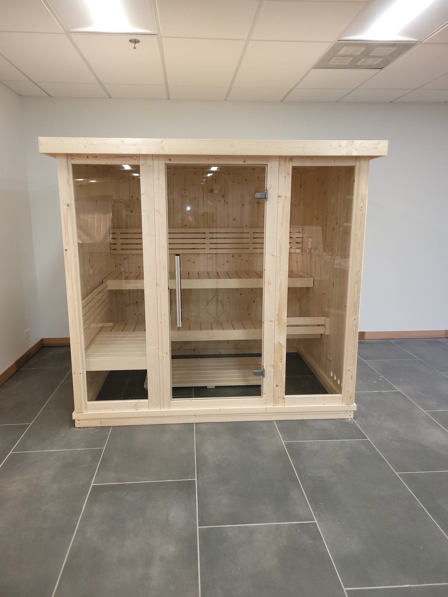 Grande sauna interna con porte in vetro temperato a Saunamo.