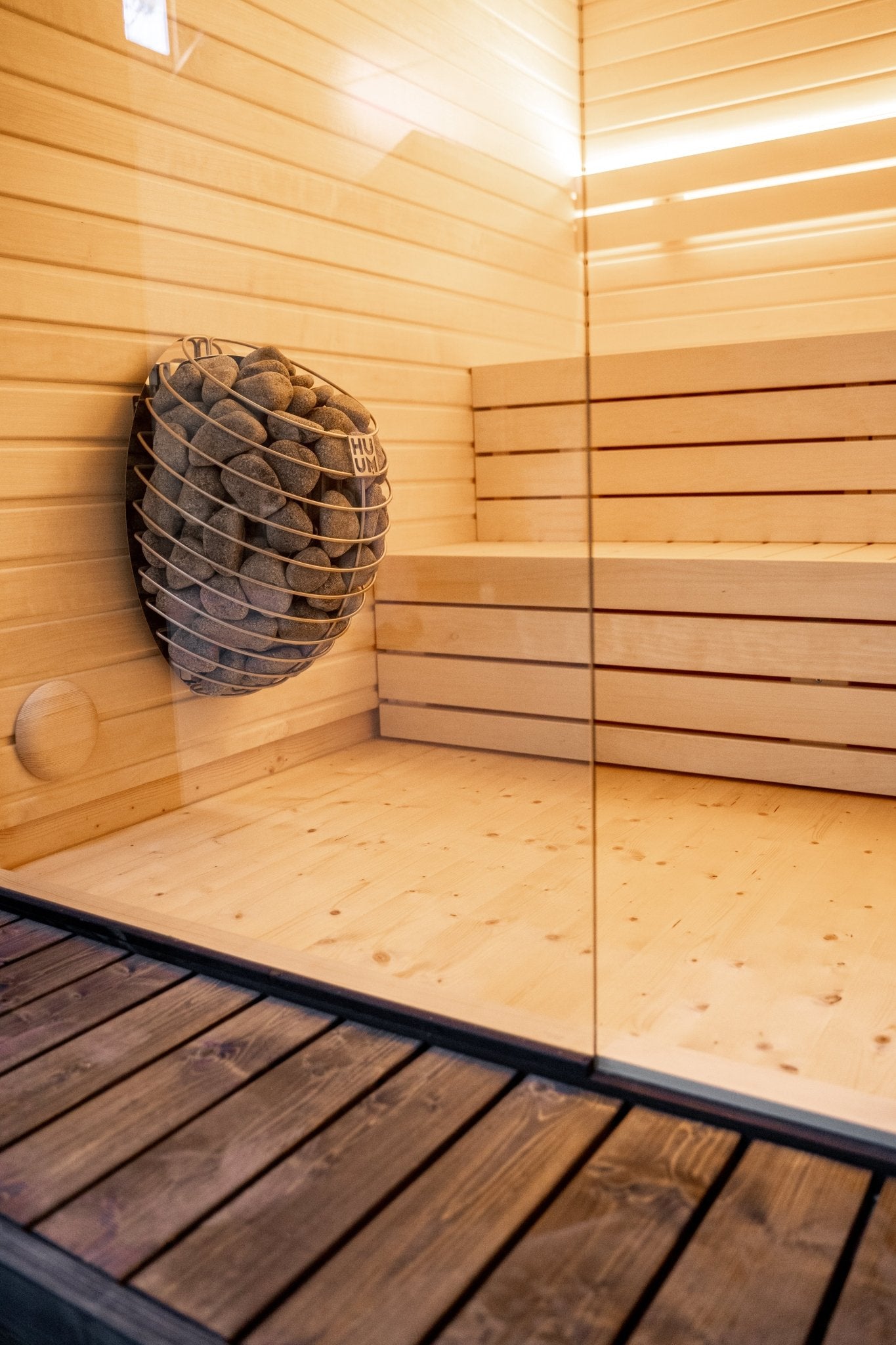 Sauna exterior Lumi con cesta de piedra.