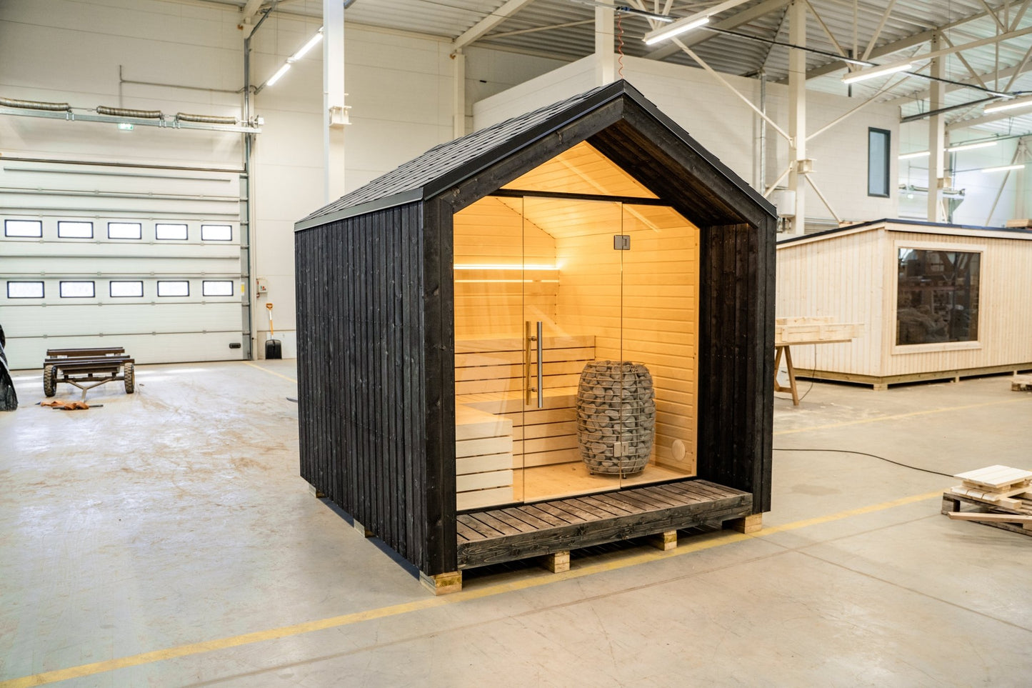Sauna de exterior Lumi con pared de cristal y diseño nórdico.