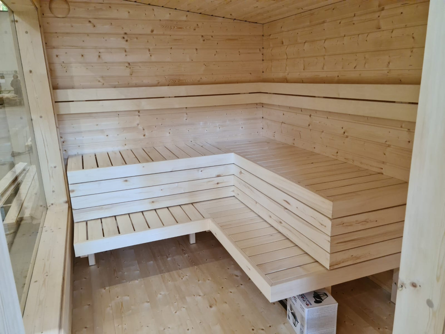 Modular outdoor sauna with wooden bench.