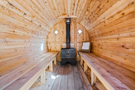 Sala de sauna com fogão e bancos de madeira.