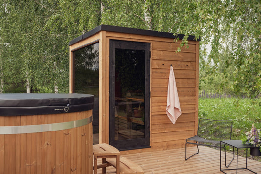 Sauna da esterno Nordic Dawn pre-assemblata in un ambiente naturale.