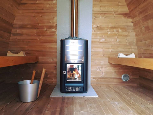 Outdoor sauna pod with wood-burning stove inside the room.