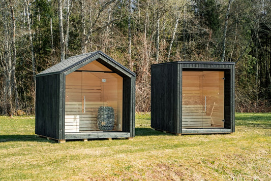 Sauna LUMI exterior isolada com porta de vidro, em área verde.